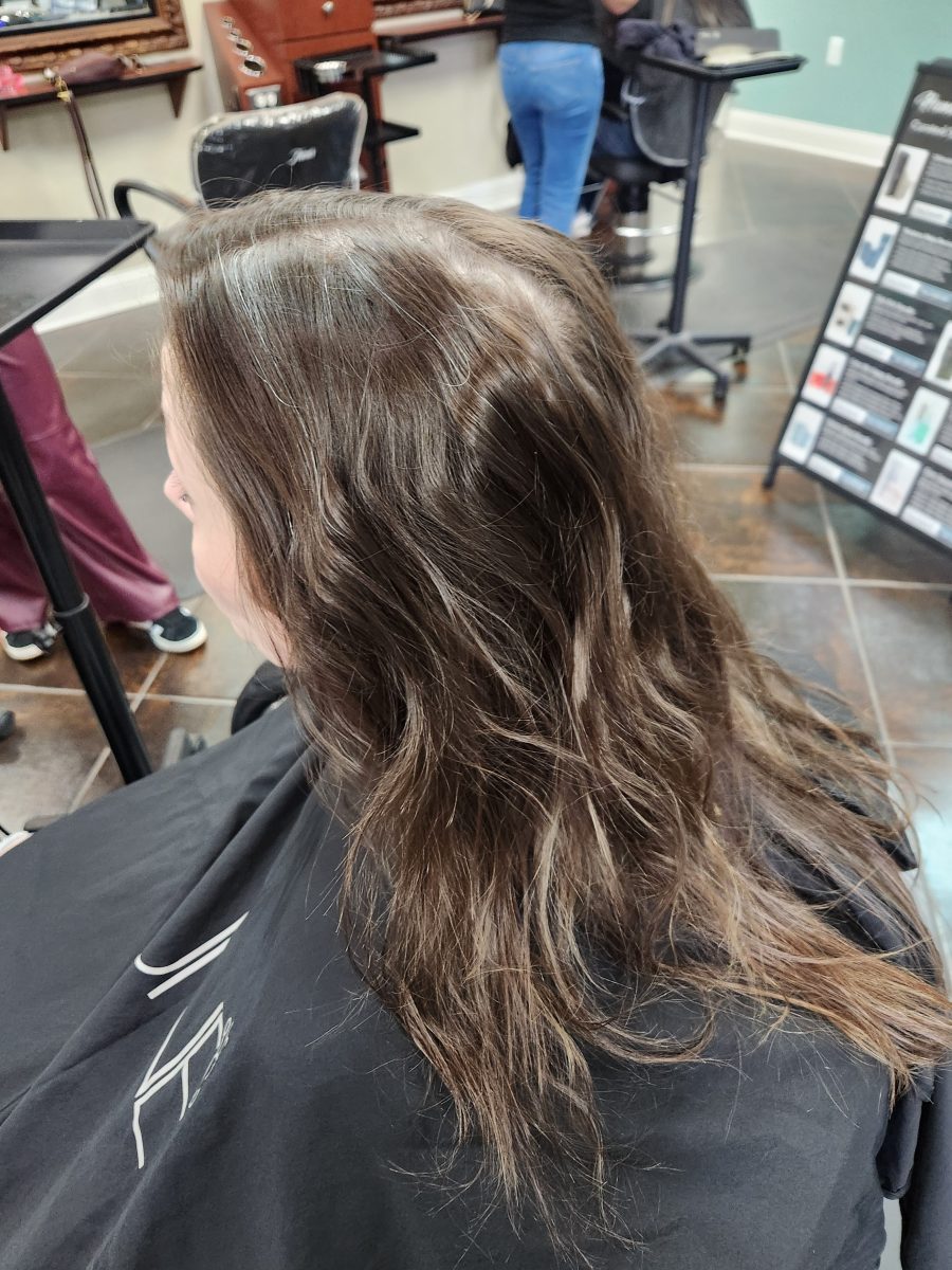 Three-quarter back view of shoulder-length wavy hair in natural brown tones by Siobhan Rozinski at K Bella Hair Studio & Spa in Brighton, MI