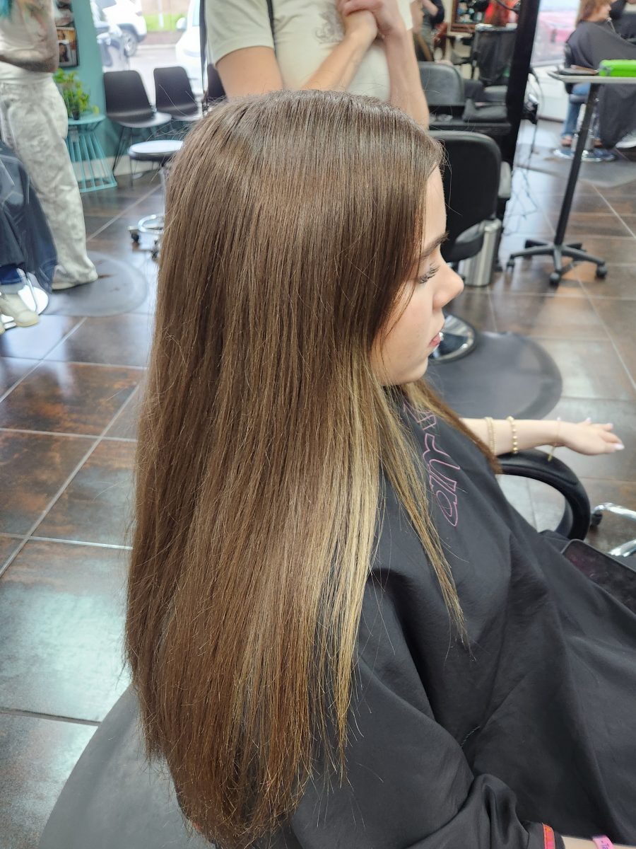 Profile view of long straight brunette hair, from shoulder down, in salon by Siobhan Rozinski at K Bella Hair Studio & Spa in Brighton, MI