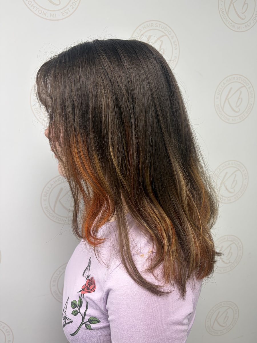 Side profile of long layered hair with copper and bronze highlights concentrated on the lower half, by Abbey French at K Bella Hair Studio & Spa in Brighton, MI