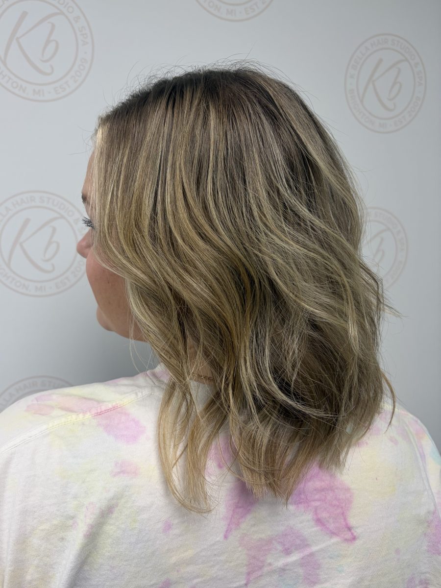 Layered shoulder-length hair with balayage, three-quarter profile view showing face-framing dimension by Abbey French at K Bella Hair Studio & Spa in Brighton, MI