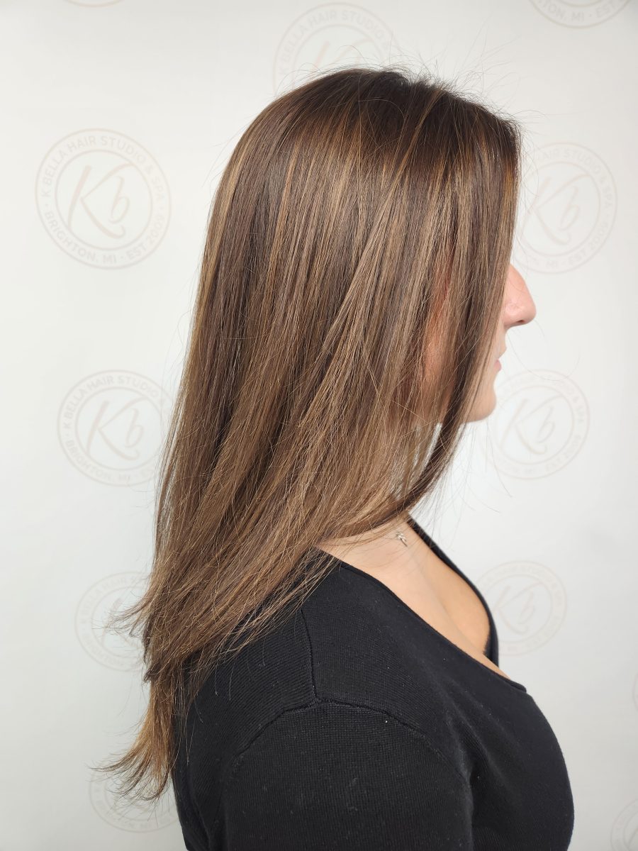 Side profile of long, straight hair with balayage highlights in warm honey tones, by Siobhan Rozinski at K Bella Hair Studio & Spa in Brighton, MI