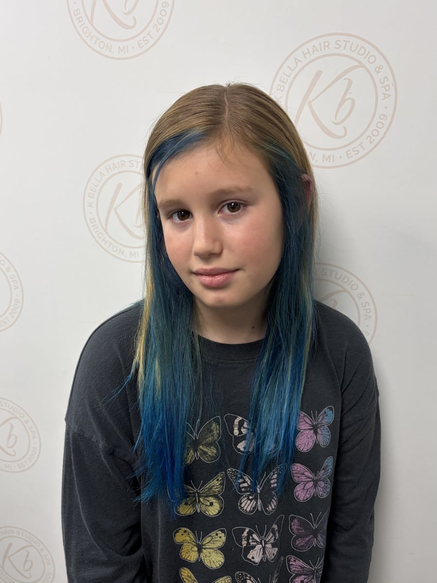 Close-up portrait of a young person with long dark hair featuring vivid blue balayage highlights throughout by Abbey French at K Bella Hair Studio & Spa in Brighton, MI