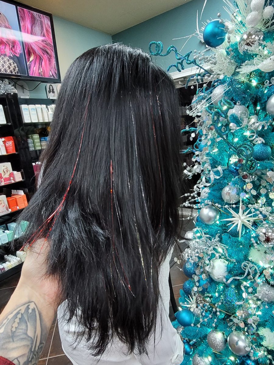 Side view of long dark ruby hair with layered texture and face-framing pieces by Kristan Sayers at K Bella Hair Studio & Spa in Brighton, MI