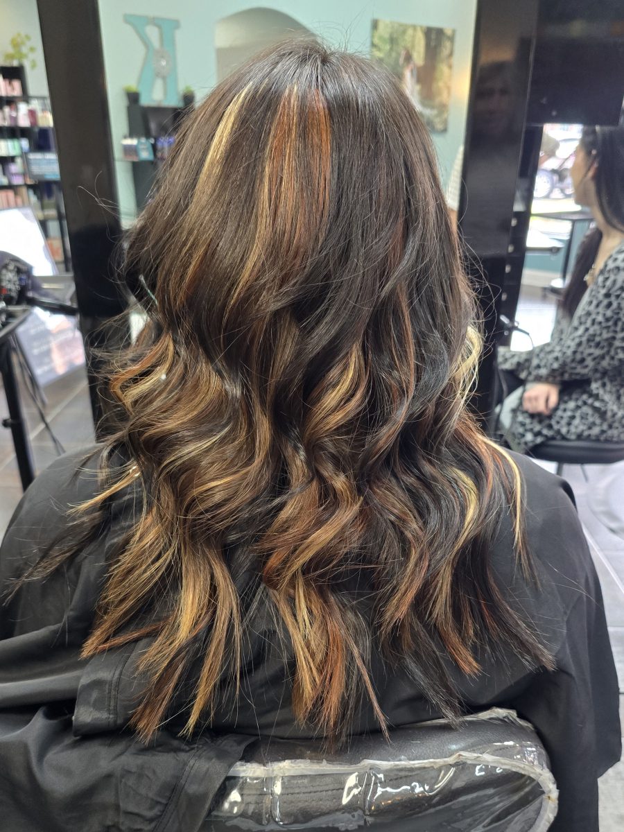 Back view of long waved hair showing dimensional copper, cream, and dark brown tones, by Katie Rowe at K Bella Hair Studio & Spa in Brighton, MI