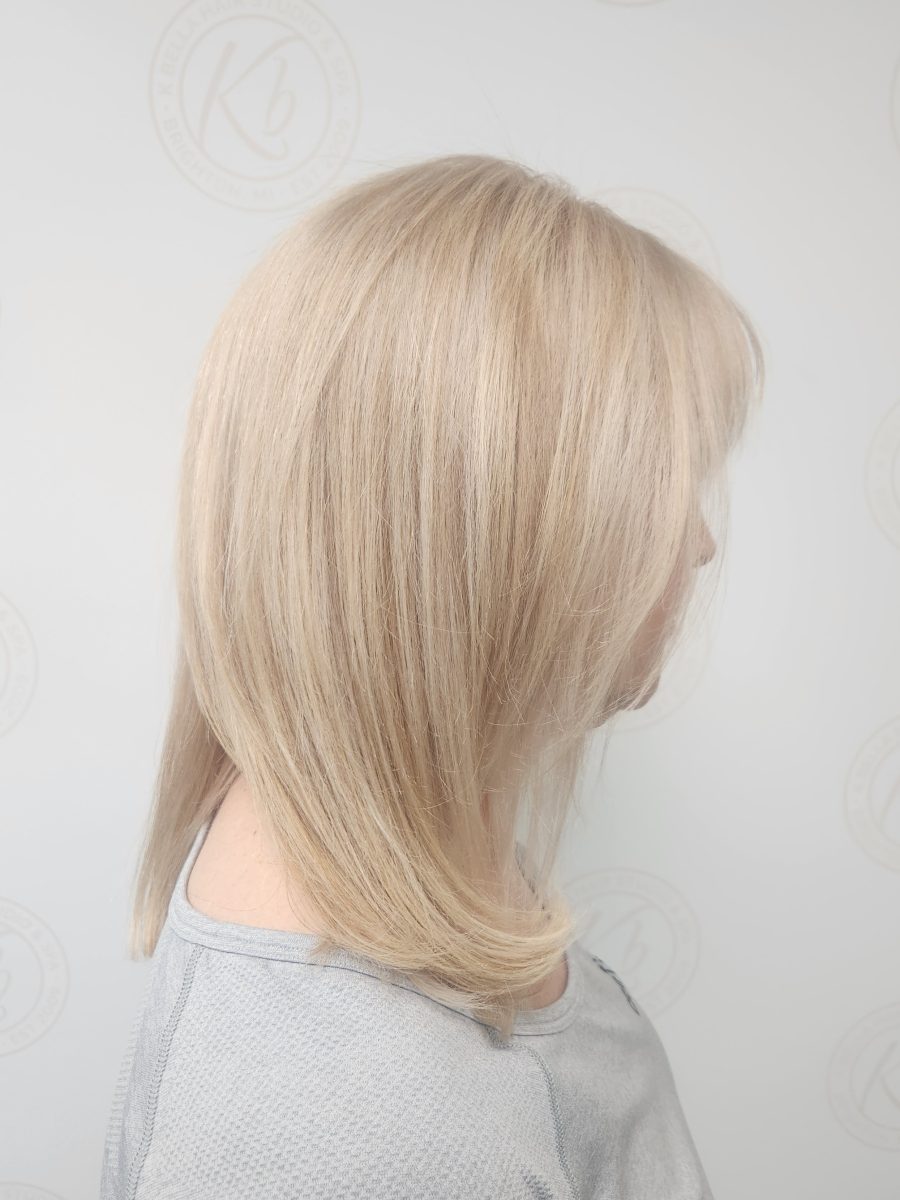 Side view of corrected blonde hair showing even tone, soft dimension, and healthy shine after color correction by Siobhan Rozinski at K Bella Hair Studio & Spa in Brighton, MI