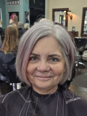Front-facing view of a short layered bob with pink balayage tones throughout by Kristan Sayers at K Bella Hair Studio & Spa in Brighton, MI