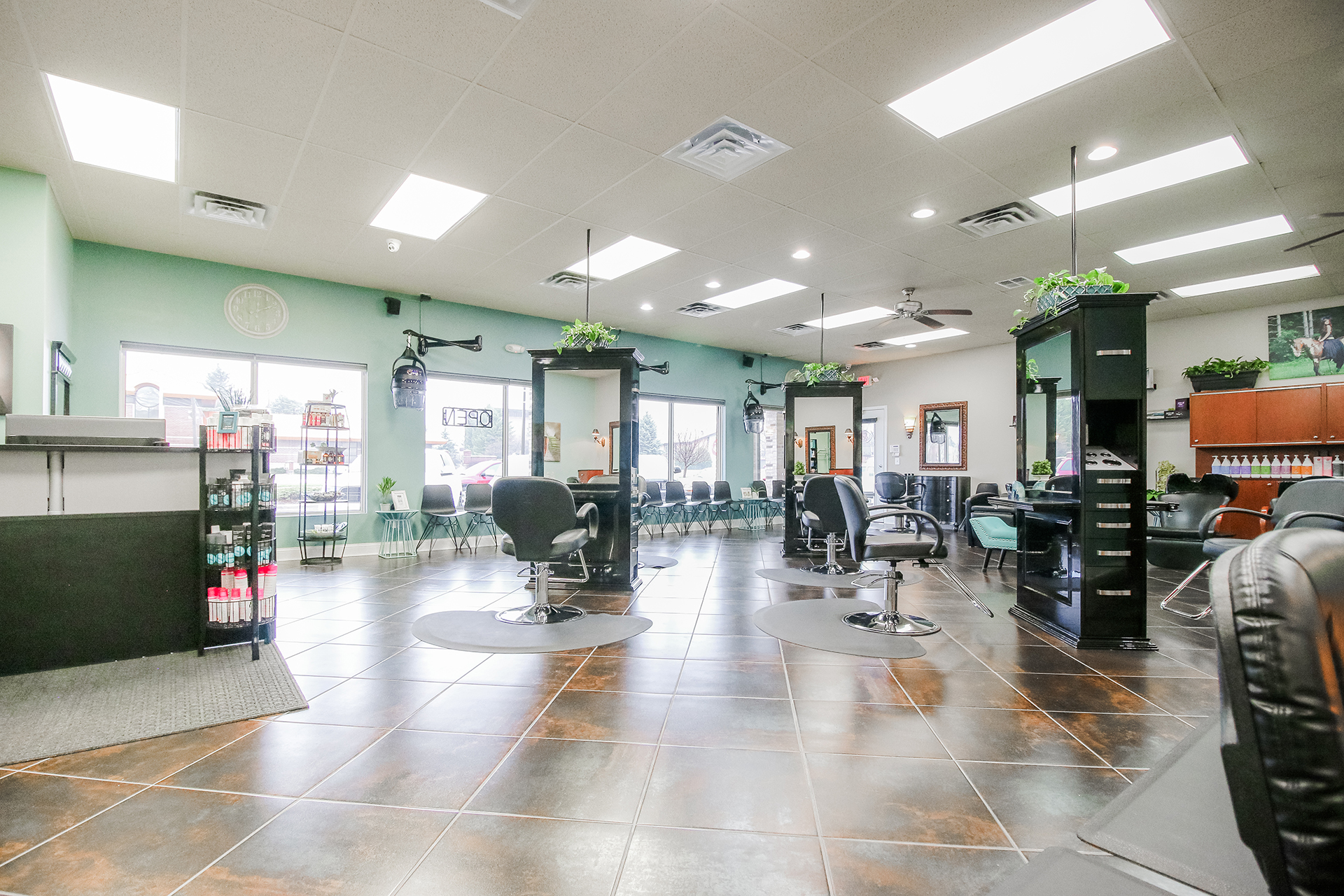The main floor of K Bella in Brighton, with stylist chairs and gold-framed mirrors