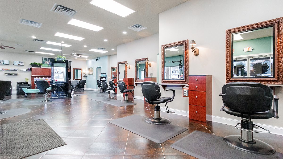 Ornate gold mirrors above stylist stations in the main salon