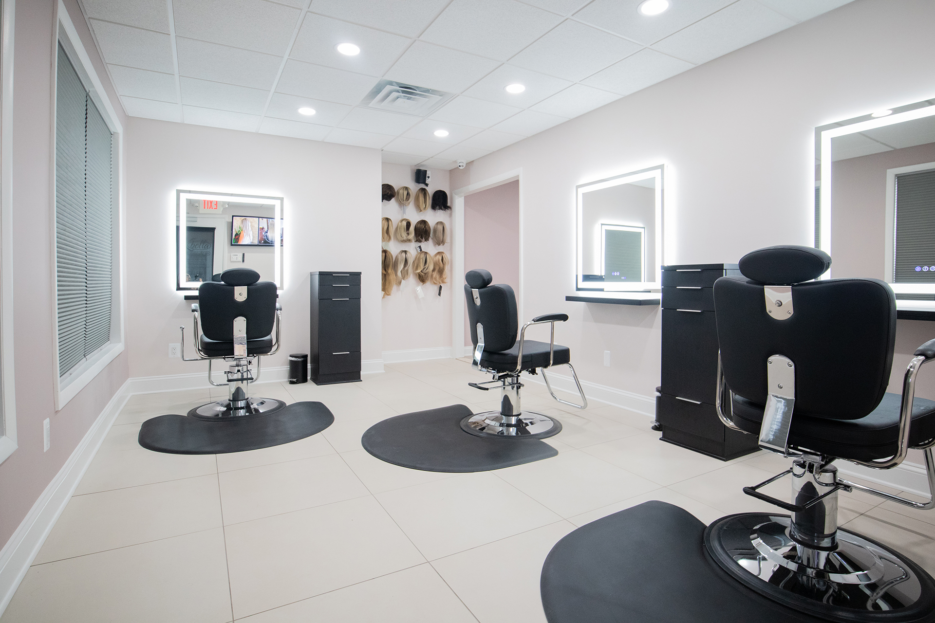 The K Bella wig studio in Brighton, Michigan - white floors and rose walls with four private vanity stations