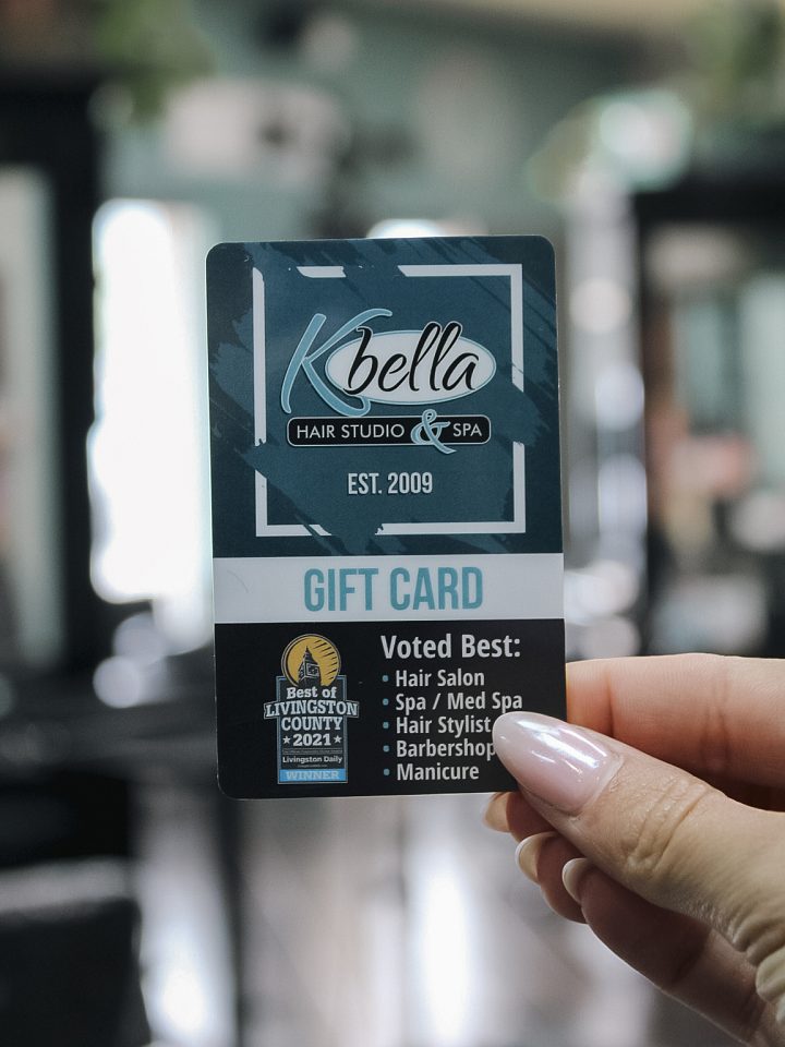 A K Bella Hair Studio &amp; Spa gift card held up in the salon